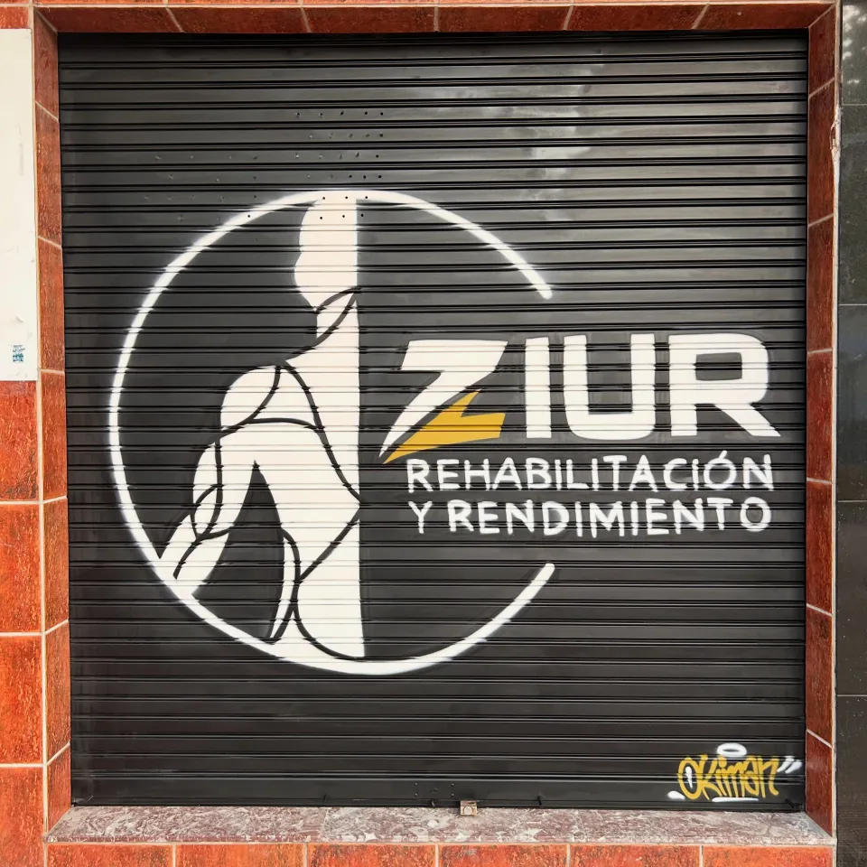 Persiana negra con el logotipo de un centro de rehabilitación y rendimiento