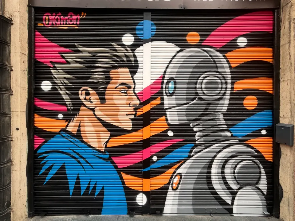 Persiana de Idenautas, en Bilbao, pintada con un chico y un robot cara a cara, en negro, naranja, rosa y azul