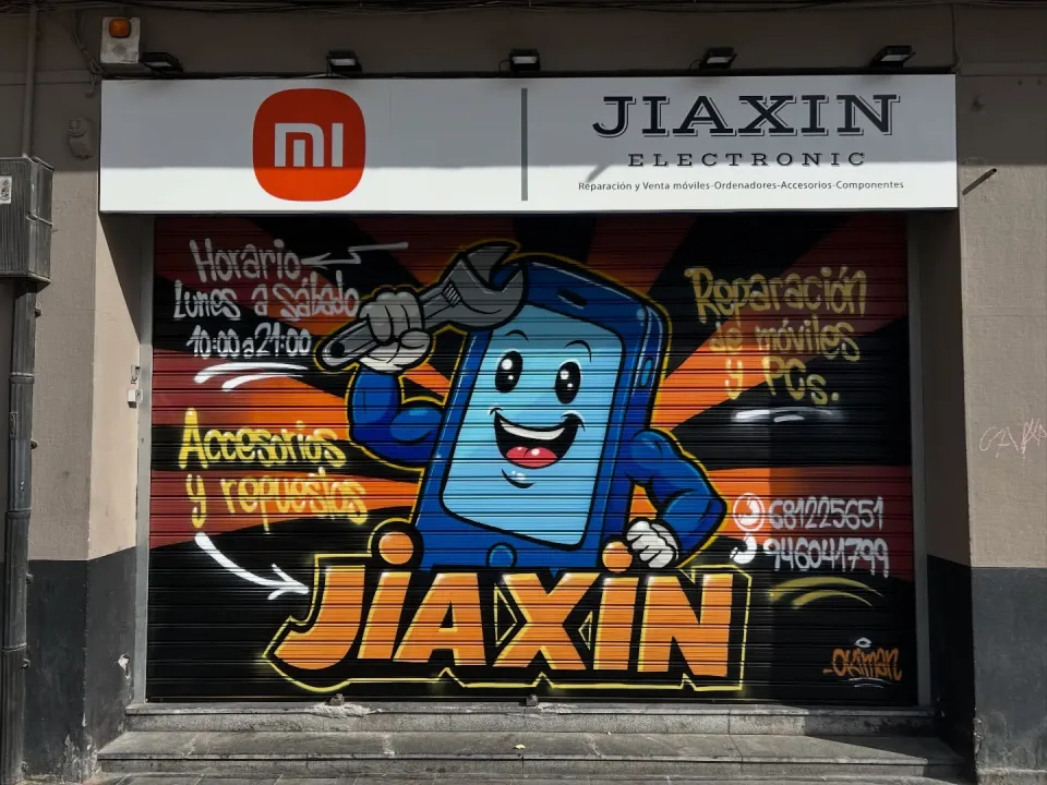 Persiana de una tienda de reparación de móviles con un teléfono sonriente que sostiene una llave inglesa